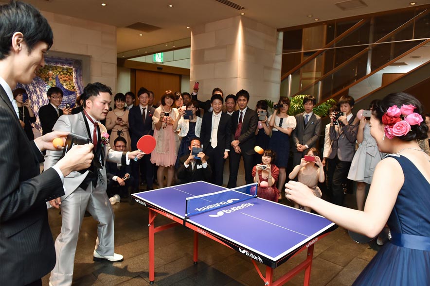 卓球をする新郎新婦