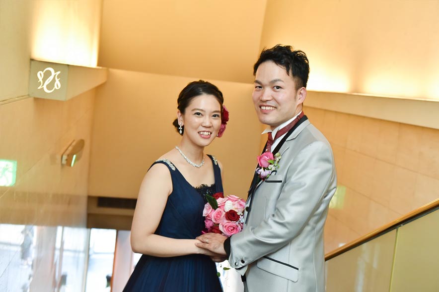 花束を手に繋ぐ新郎新婦